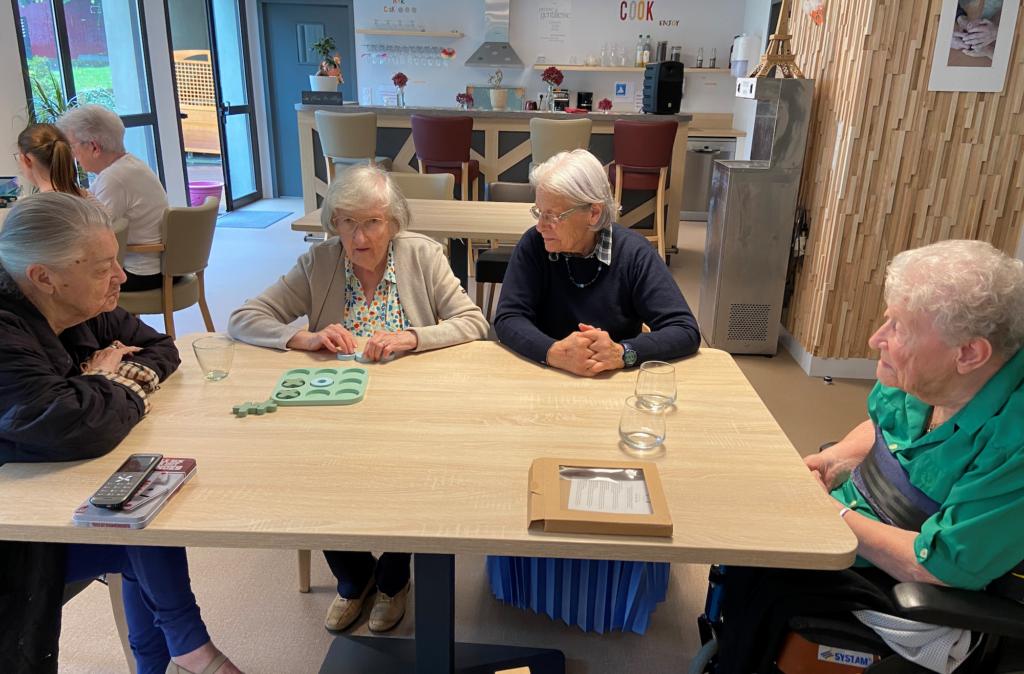 Des habitants de la Maison Saint-Louis jouant à un jeu à la « Place du village » un espace collectif dédié aux activites